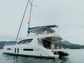 A stunning catamaran docked in calm waters, showcasing its sleek design and spacious layout, perfect for luxurious sailing adventures.