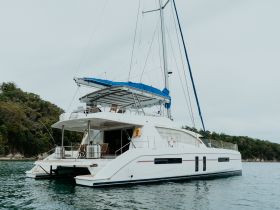A stunning yacht anchored in calm waters, showcasing its elegant design and spacious deck, perfect for luxury charters and relaxing getaways.