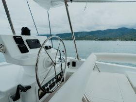 A clean and modern helm area of a boat, showcasing the steering wheel and control panel, perfect for navigating the serene waters.