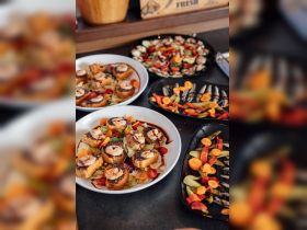 A beautifully arranged spread of gourmet dishes, including shrimp appetizers and fresh salads, perfect for onboard dining experiences.
