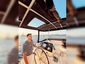 A man navigates the helm of a boat, showcasing the modern console and controls, perfect for a day of sailing on the open water.