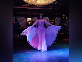 A captivating dancer performs on a boat, showcasing an enchanting belly dance that adds a unique entertainment experience for guests on board.