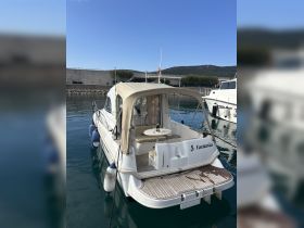 A beautifully docked yacht named 'Fantasia' showcases its elegant design and serene surroundings, perfect for a relaxing day on the water.