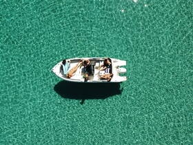 Aerial view of a group relaxing on a small boat in crystal-clear turquoise waters, perfect for a day of fun and sun on the water.