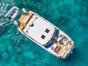 Aerial view of a group enjoying a sunny day on a boat, perfect for relaxation and fun in the turquoise waters.