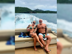 A couple enjoys a relaxing moment on a boat, sipping drinks and taking in the scenic views — perfect for a day out on the water.