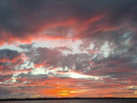 A breathtaking sunset paints the sky in vibrant hues of orange and pink, creating a stunning backdrop for any boating adventure.