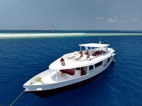 A group enjoys a relaxing day on a boat, soaking up the sun against a stunning ocean backdrop — perfect for leisure and adventure on the water.