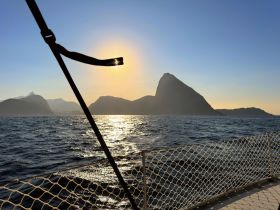 A stunning sunset view over the coastline, with silhouettes of mountains creating a picturesque backdrop — perfect for capturing the beauty of a boating adventure.