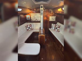 Interior view of a cozy boat cabin featuring comfortable seating and nautical decor, perfect for relaxing during voyages.