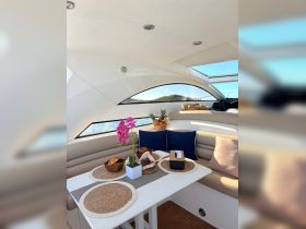 A beautifully arranged dining area inside a boat, featuring elegant decor and a cozy seating arrangement, perfect for enjoying meals while cruising on the water.
