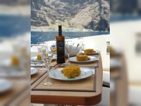 A beautifully set dining table on a yacht featuring gourmet dishes and fine wine, perfect for an elegant onboard dining experience.