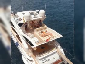 A group of friends relaxes on the deck of a luxurious yacht, soaking up the sun and enjoying a perfect day on the water.