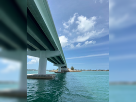 A view of a bridge over turquoise waters, capturing the serene atmosphere of a coastal landscape.