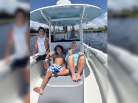 A group of friends relaxes on a boat, enjoying a sunny day on the water — perfect for summer adventures and bonding time.
