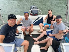 A group of friends enjoys a fun day on the water aboard a boat, showcasing camaraderie and relaxation in a lively atmosphere.
