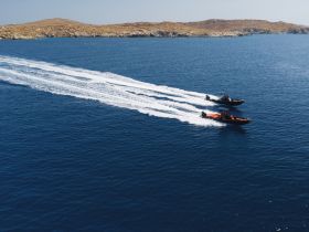 Aerial view of two speedboats racing across the deep blue waters, showcasing the thrill of boating adventures.