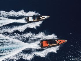 Aerial view of two speedboats racing through deep blue waters, showcasing the thrill of boating adventures on the open sea.