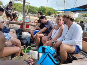 A diverse group of people relaxes and engages in conversation aboard a boat, enjoying their time together before heading to their next adventure.