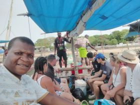 A lively group enjoys their time aboard a boat, with a mix of guests and crew interacting, showcasing the vibrant atmosphere of a boating experience.