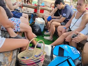 Guests relax inside a boat, enjoying the ride while seated on a wooden bench. The cozy interior is perfect for socializing during a day on the water.