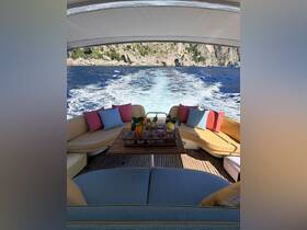 A beautifully arranged lounge area inside a boat, featuring comfortable seating and a table with refreshing drinks, perfect for relaxing while cruising on the water.