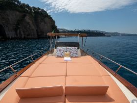 A cozy lounge area on a boat featuring plush cushions, perfect for relaxing while enjoying scenic views on the water.