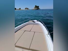 A clear view of the front deck of a speedboat, showcasing comfortable seating and a serene turquoise backdrop — perfect for a day on the water.