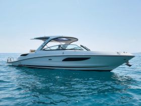 A sleek speedboat glides through clear blue waters, showcasing its elegant design and perfect for thrilling day trips on the ocean.