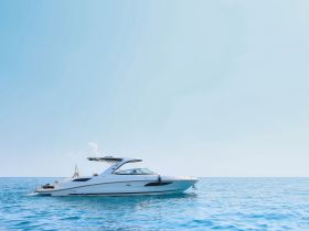 A stunning side view of a sleek yacht cruising through calm blue waters, perfect for luxury outings and summer adventures on the sea.