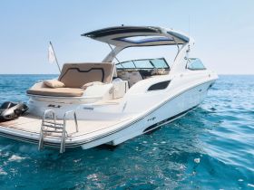 A sleek SLX yacht glides through crystal-clear waters, showcasing its elegant design and luxurious features, perfect for a day on the water.
