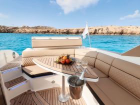 A beautifully arranged table on a boat featuring fresh fruits and cocktails, perfect for a luxurious day on the water.