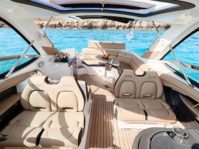 A beautifully designed interior of a Sea Ray boat featuring luxurious seating and a well-appointed helm, perfect for a comfortable day on the water.