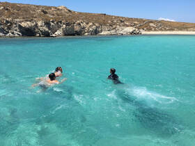 A group of swimmers enjoys the crystal-clear turquoise waters at a beautiful beach, perfect for a fun day in the sun.