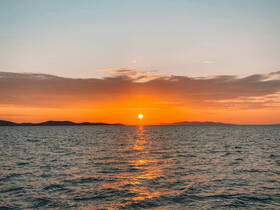 A stunning sunset over tranquil waters, showcasing the beauty of nature — perfect for evening boat cruises.