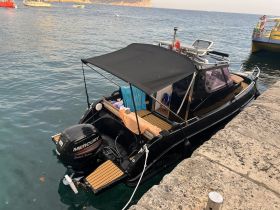 A sleek speedboat docked at the harbor, showcasing its stylish design and equipped with a Mercury outboard motor, perfect for a day on the water.