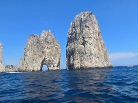 Stunning view of iconic rock formations rising from the ocean, showcasing the natural beauty of the coastline — a must-see landmark for boat tours.