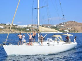 A lively group celebrates aboard a sailing yacht, enjoying the sun and sea — perfect for memorable adventures in beautiful destinations.