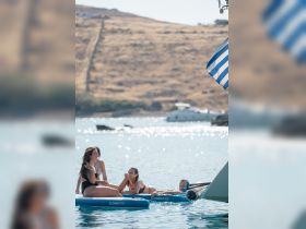 A group of friends enjoys a sunny day paddleboarding in clear waters, creating perfect summer memories on the water.
