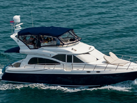 A sleek yacht cruising through clear waters, showcasing its elegant design and spacious deck, perfect for luxury outings on the water.