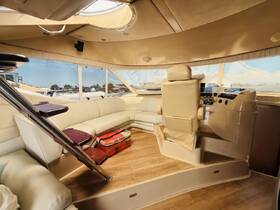 Interior view of a luxurious boat cabin featuring comfortable seating and a helm, perfect for relaxing or navigating on the water.