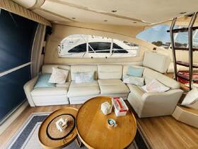 A cozy lounge area inside a boat featuring comfortable seating and decorative pillows, perfect for relaxing during a day on the water.