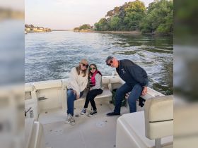 A joyful family poses on a boat, capturing a fun moment together on the water — perfect for family outings and memorable adventures.