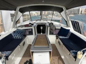 Interior view of a yacht's cabin featuring comfortable seating and a well-equipped helm area, perfect for relaxing and navigating on the water.