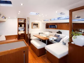 A beautifully designed interior of a yacht featuring a spacious dining area and comfortable seating, perfect for relaxing and entertaining while on the water.