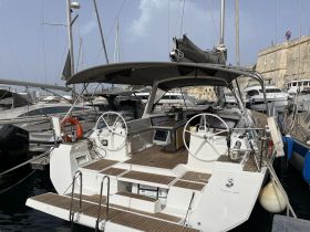 A detailed view of the helm and interior of a sailing yacht, showcasing the modern design and features ideal for navigation and comfort.