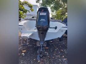 A clear view of the back of a boat featuring its motor, showcasing the sleek design and functionality, ideal for boating enthusiasts.