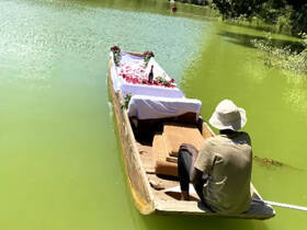 A serene scene featuring a decorated boat on vibrant green waters, perfect for romantic celebrations or special occasions.