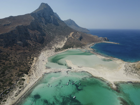 A stunning aerial view of a picturesque beach and coastline, showcasing the vibrant turquoise waters and sandy shores, perfect for island hopping adventures.