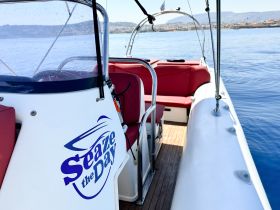 Interior view of the helm and seating area on a boat named 'Seaze the Day', showcasing a comfortable and stylish space for navigation and relaxation.